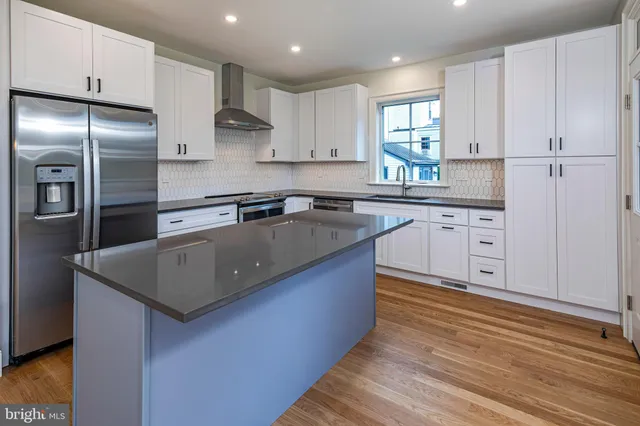 a kitchen with stainless steel appliances granite countertop a sink a stove and refrigerator