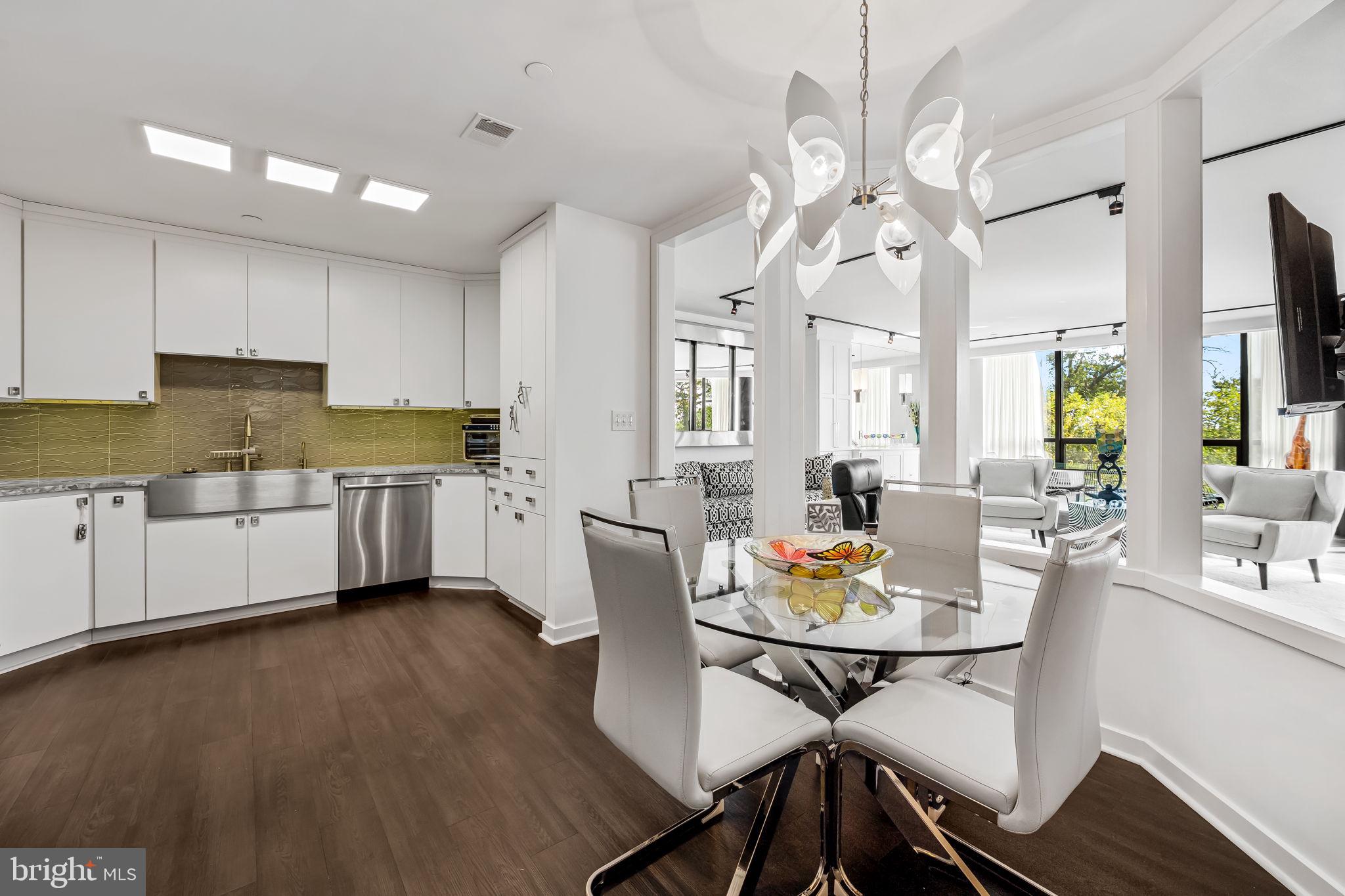 4001 Old Court Road, Unit 517 Baltimore, MD 21208 - Photo 13 of 38 a open dining room with stainless steel appliances kitchen island granite countertop a table chairs and a living room view