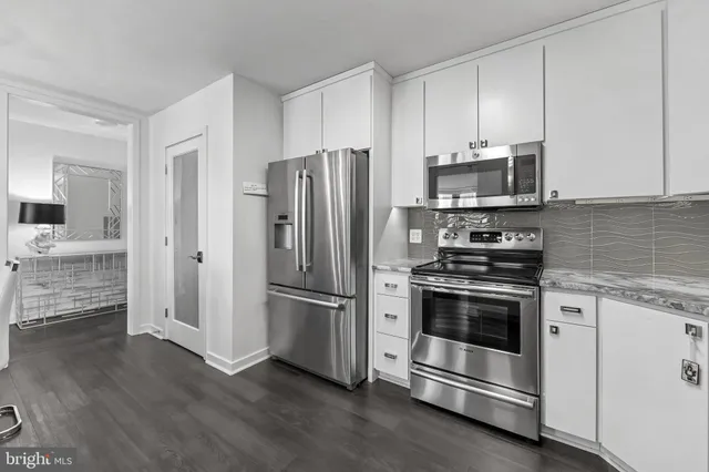 a kitchen with stainless steel appliances and white cabinets