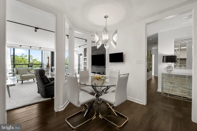 a view of a dining room with furniture a chandelier and wooden floor