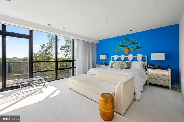 a bedroom with a bed and large windows