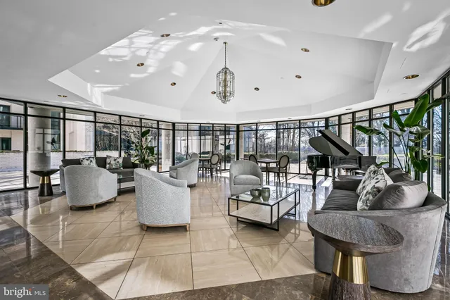 a living room with couches and kitchen view with wooden floor