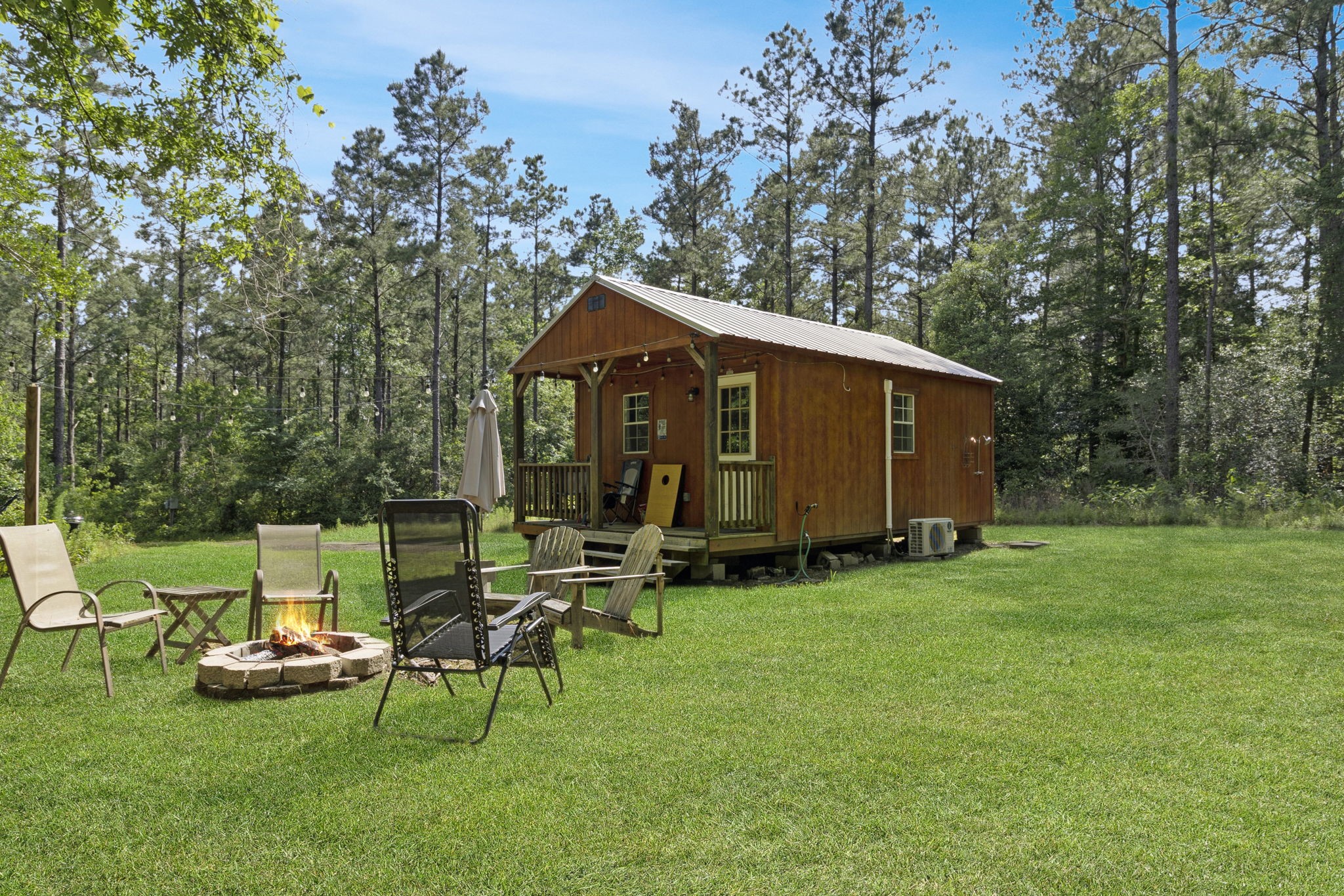 129 County Road 3160 Colmesneil, TX 75938 - Photo 2 of 40 Relax and unwind at the outdoor fire pit area, complete with seating and hammocks. Perfect for gathering under the stars or a friendly game of corn hole.