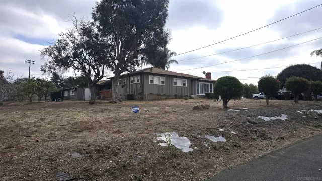 a view of a dry yard with wooden fence