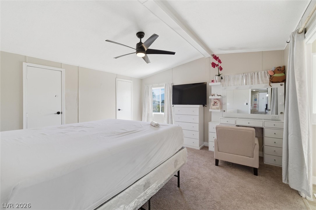 4331 Retread Road Pahrump, NV 89048 - Photo 14 of 31 A well-lit bedroom with soft carpet flooring and a ceiling fan, offering a comfortable personal retreat.
