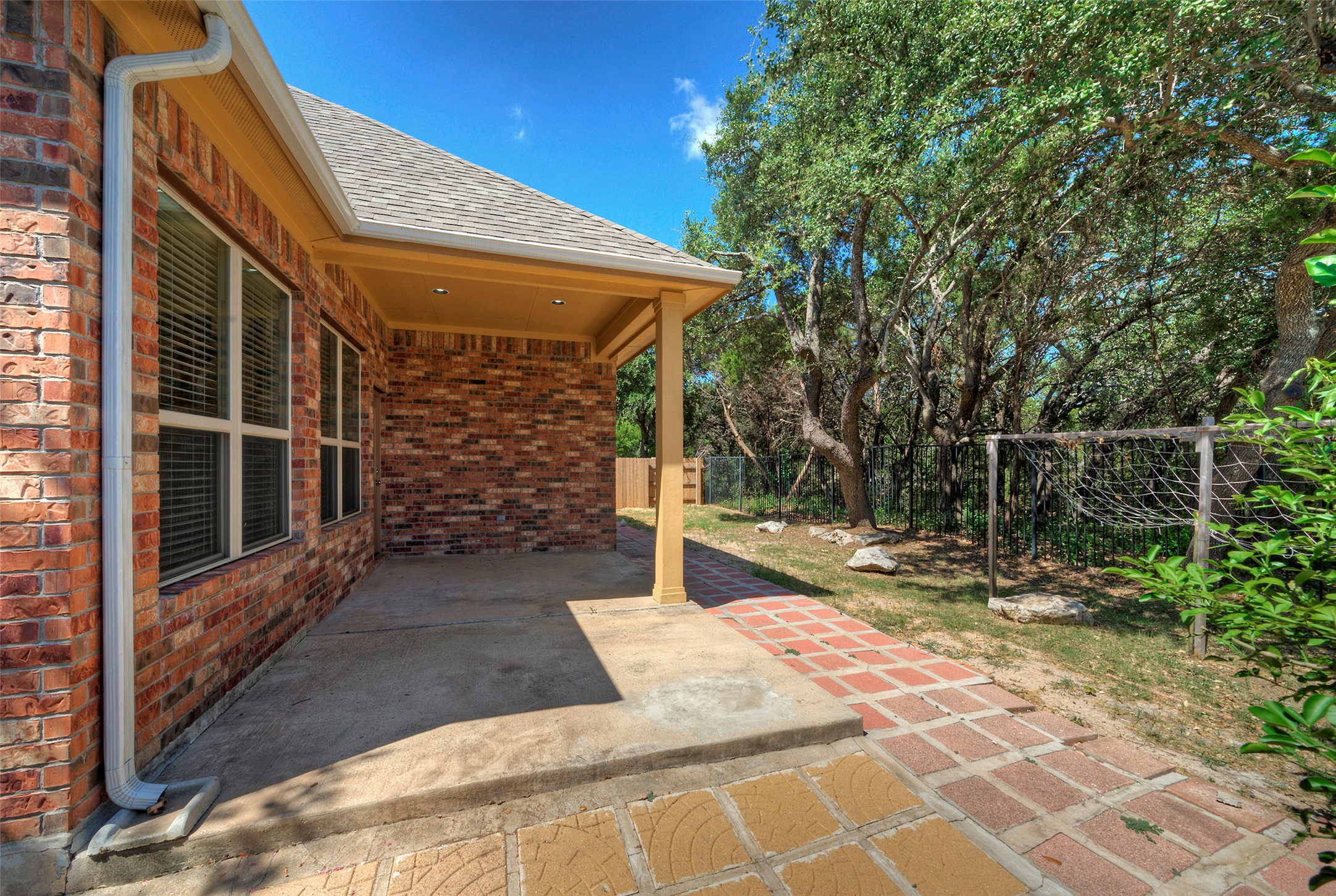 1601 Nelson Ranch Loop Cedar Park, TX 78613 - Photo 6 of 30 An inviting covered patio features concrete flooring alongside brick walls and a paved walkway.