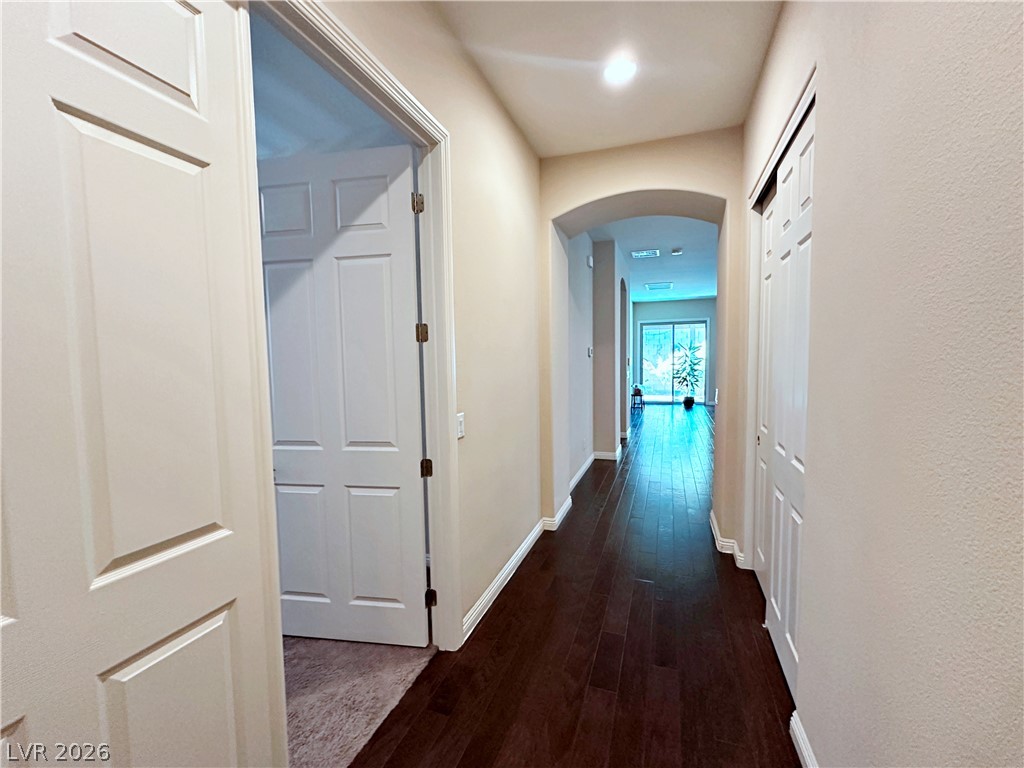 71 Newton Ridge Way Las Vegas, NV 89183 - Photo 5 of 40 An inviting hallway with rich hardwood flooring leads to sun-drenched living areas.