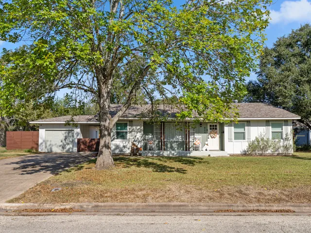 a front view of a house with a yard and trees