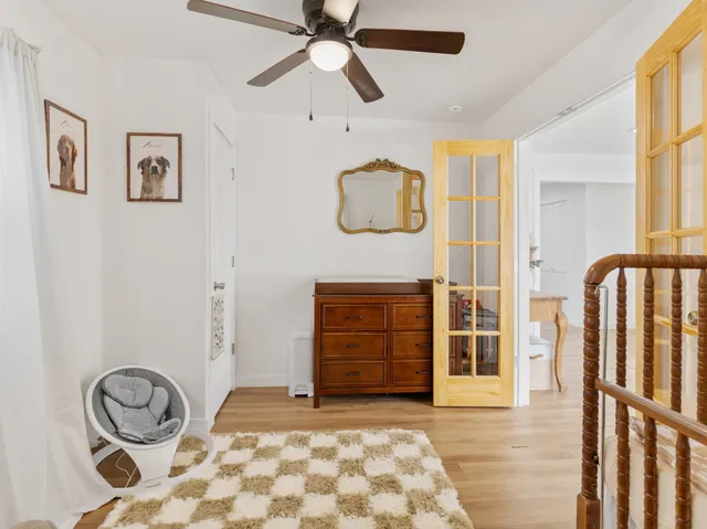 a kitchen with white cabinets stainless steel appliances and wooden floor