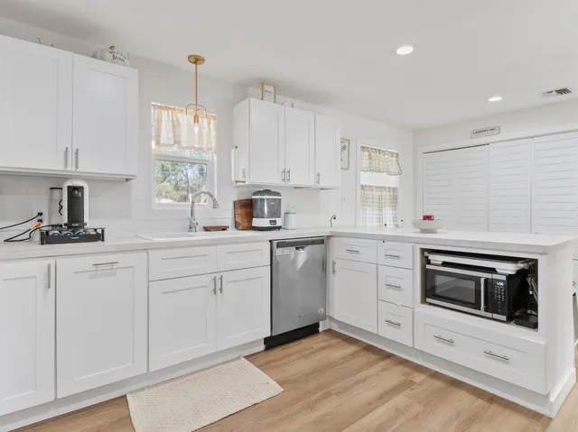 a bedroom with a large bed a chandelier and a window