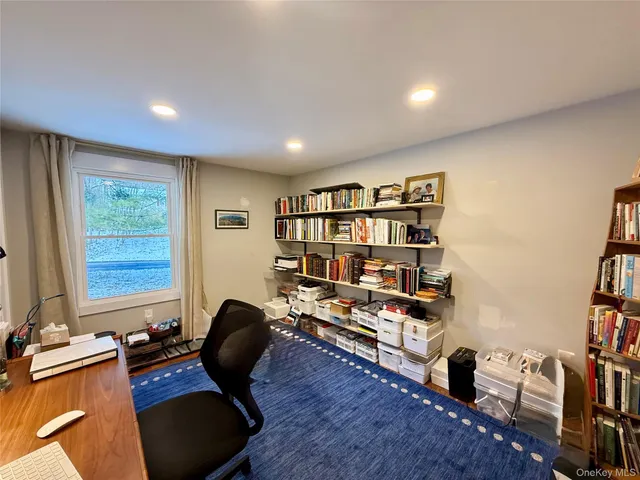 a view of a workspace with furniture and a bookshelf