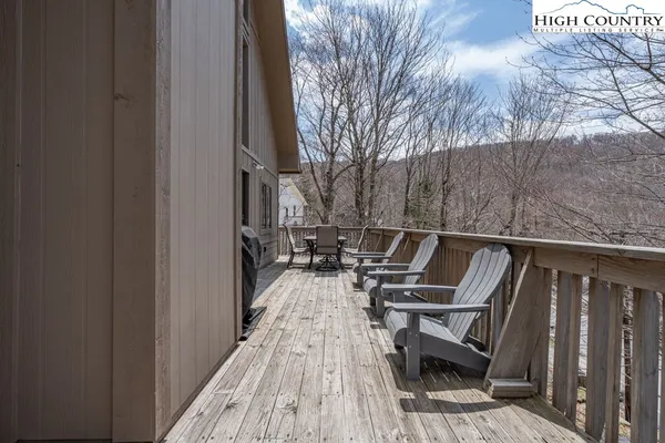 a balcony with wooden floor and outdoor seating