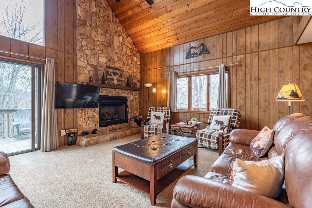 136 Tamarack Road Beech Mountain, NC 28604 - Photo 3 of 20 a living room with furniture a fireplace and a flat screen tv