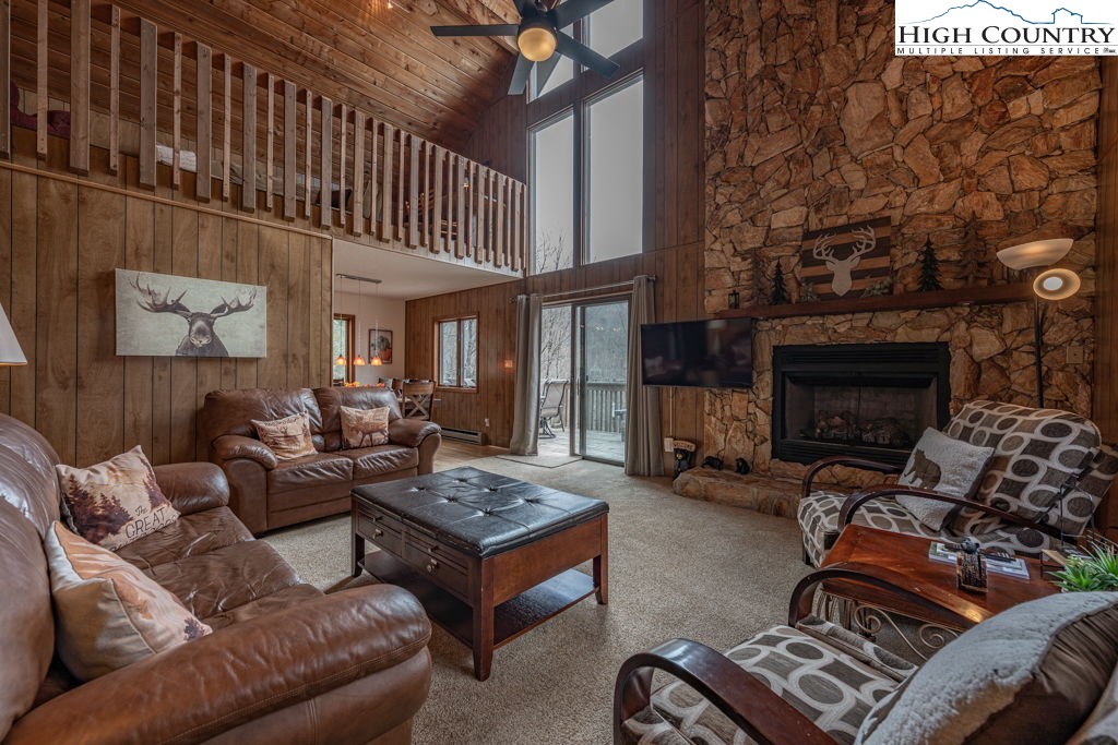 136 Tamarack Road Beech Mountain, NC 28604 - Photo 5 of 20 a living room with furniture a fireplace and a flat screen tv
