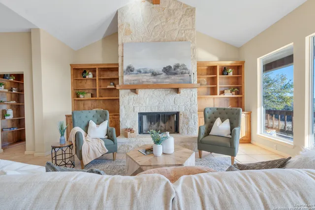a living room with furniture fireplace and a large window