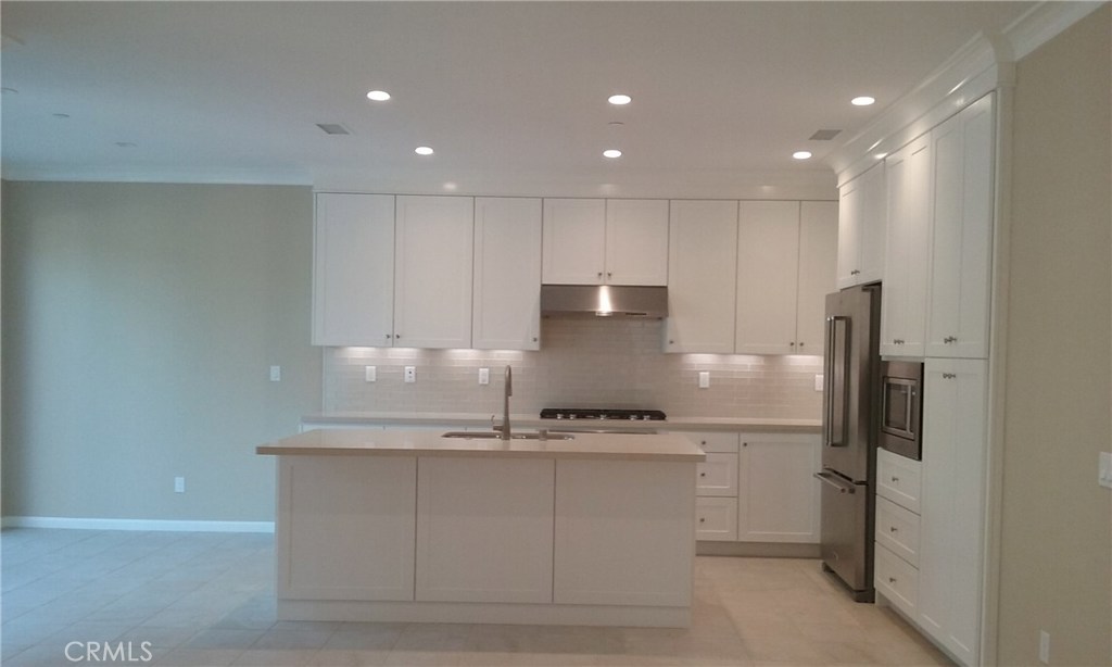 182 Working Ranch Irvine, CA 92602 - Photo 2 of 21 a kitchen with kitchen island a counter top space cabinets and stainless steel appliances