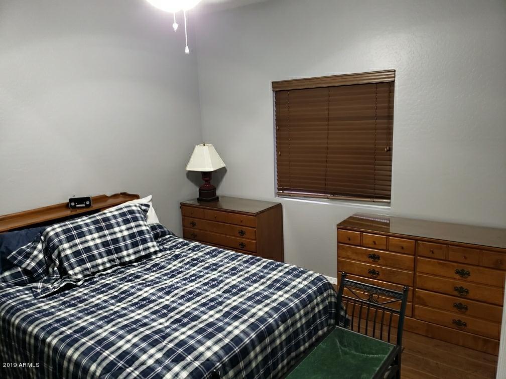 15801 West Redfield Road Surprise, AZ 85379 - Photo 20 of 26 a bedroom with a bed and wooden floor