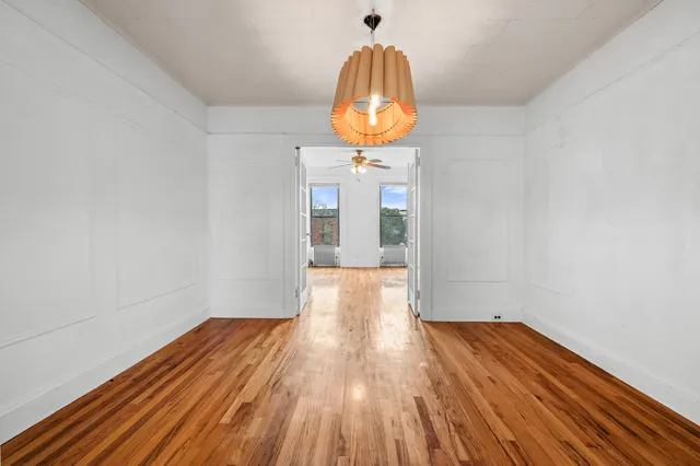 a view of empty room with wooden floor and fireplace