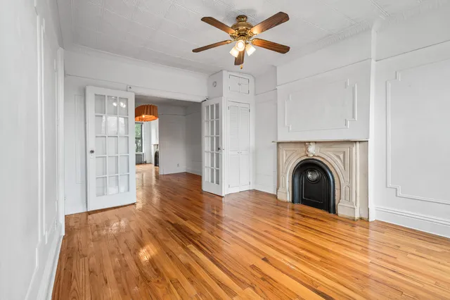 a view of empty room with fireplace and wooden floor