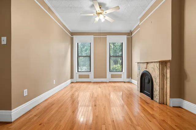 a view of a hallway with wooden floor and staircase