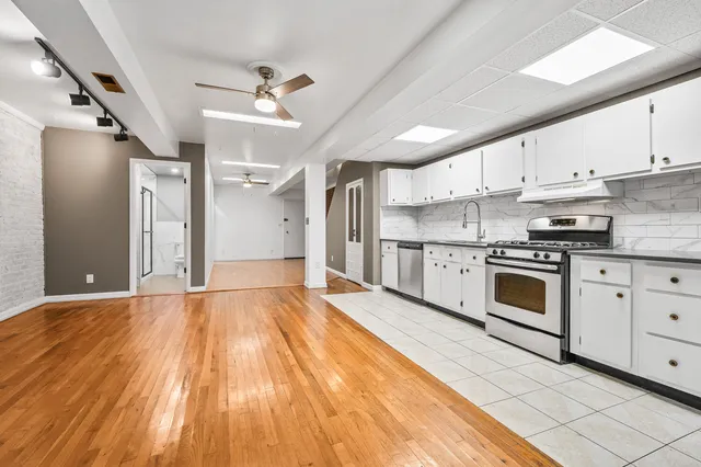 a kitchen with granite countertop white cabinets and stainless steel appliances