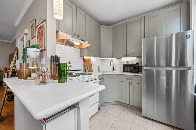 a living room with stainless steel appliances kitchen island granite countertop a refrigerator and a stove top oven