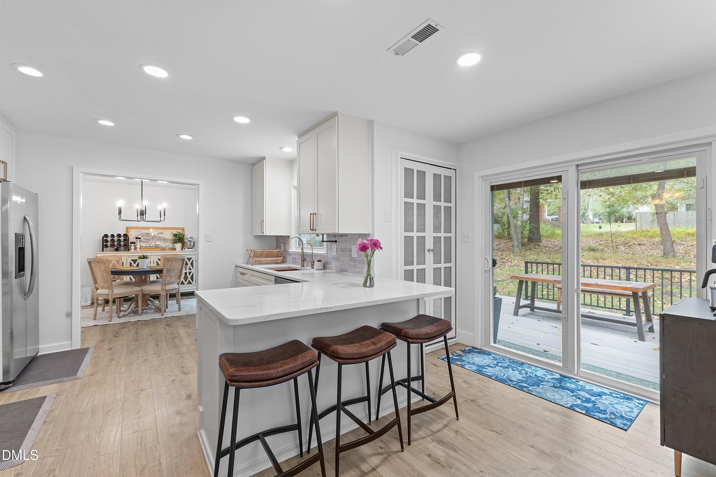 5310 Reams Run Road Durham, NC 27713 - Photo 13 of 38 a kitchen with stainless steel appliances a dining table chairs and wooden floor