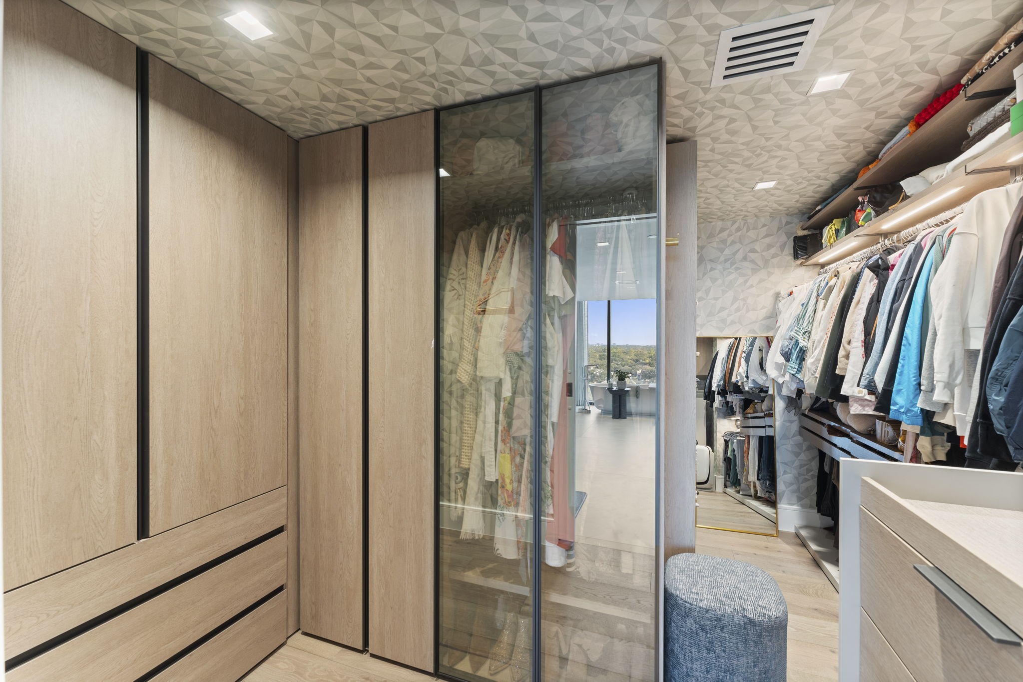 3433 Westheimer Road, Unit 1005 Houston, TX 77027 - Photo 29 of 47 Boutique closet with glass displays and Lee Jofa wallpaper—part dressing room, part private salon.