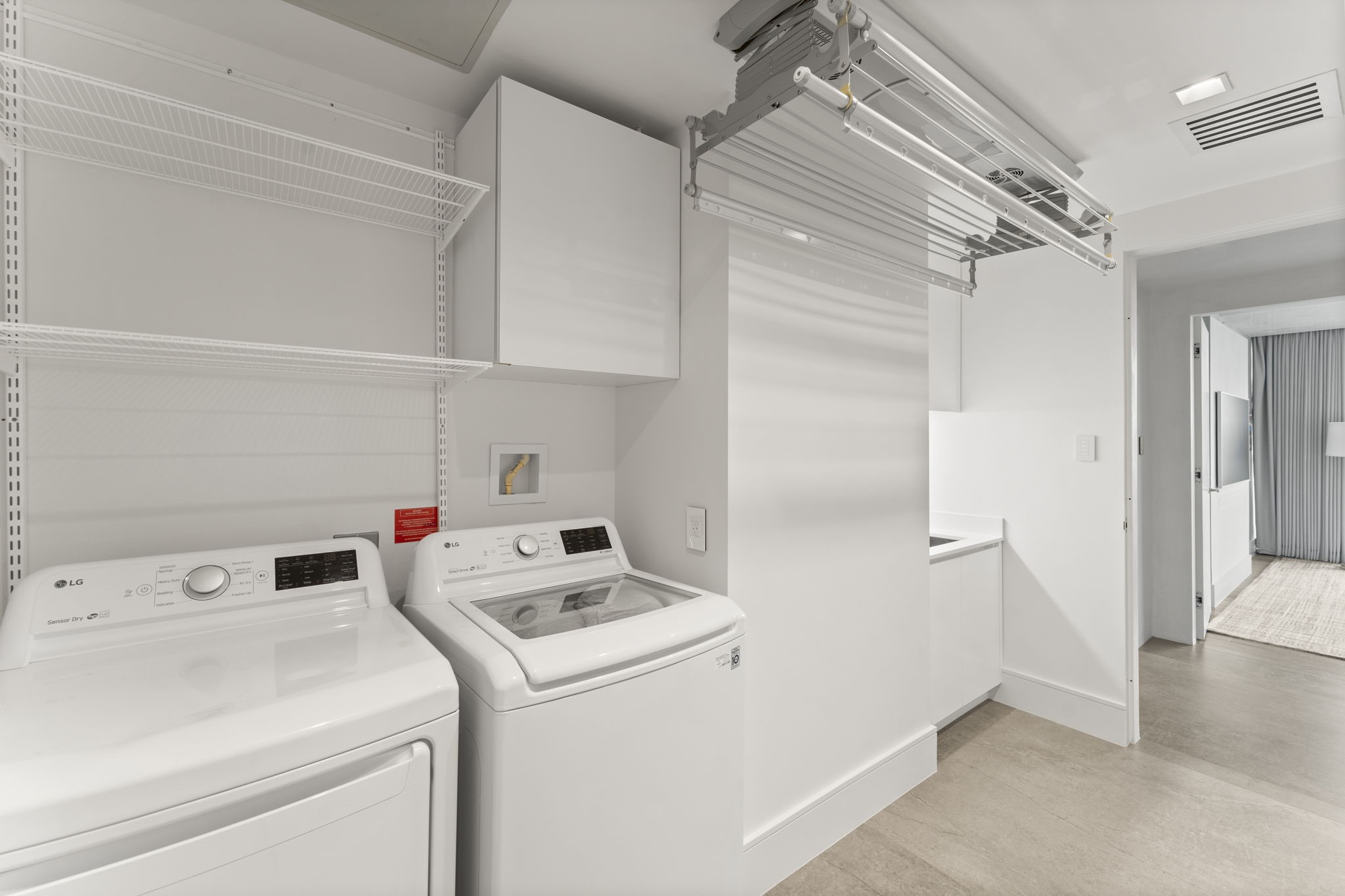3433 Westheimer Road, Unit 1005 Houston, TX 77027 - Photo 37 of 47 A real laundry room—full-height storage, work surface, and Foxydry ceiling-mounted, retractable drying rack—because luxury is in the daily rituals.