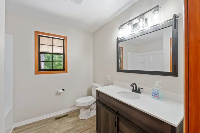 a bathroom with a toilet sink and mirror