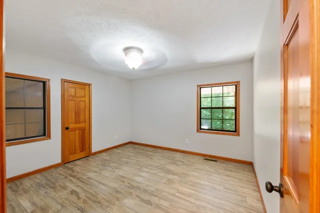 an empty room with windows and closet