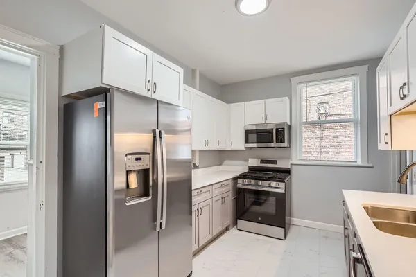 a kitchen with granite countertop a refrigerator and a stove top oven
