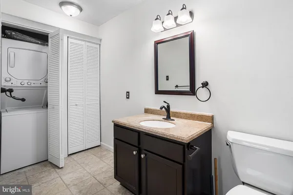 a bathroom with a granite countertop sink toilet and mirror