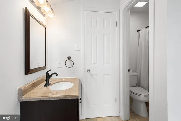 a bathroom with a granite countertop sink toilet and shower