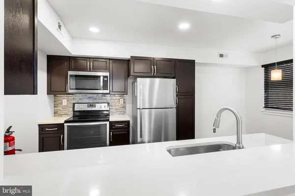 a kitchen with granite countertop a refrigerator and a sink