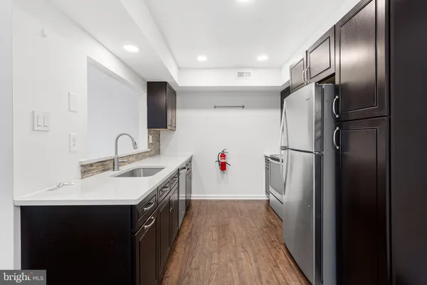 a kitchen with refrigerator cabinets and wooden floor