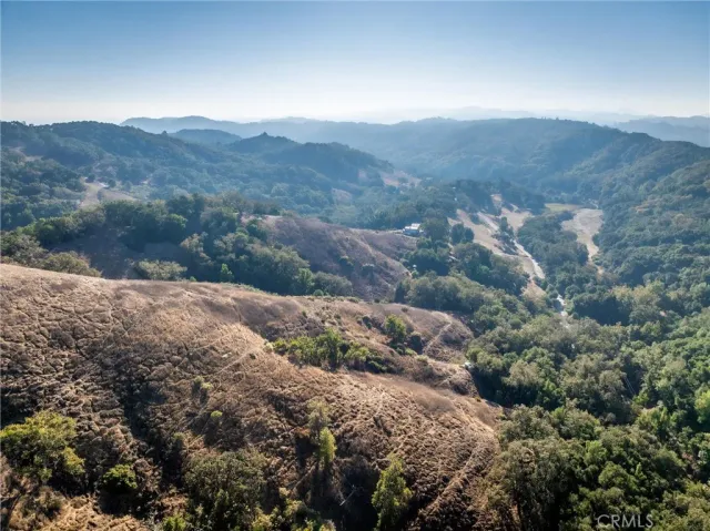 a view of a mountain range with lush green forest