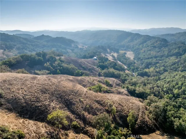 a view of a mountain range with lush green forest