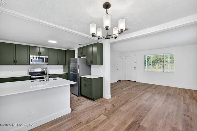 a kitchen with stainless steel appliances a stove refrigerator and microwave