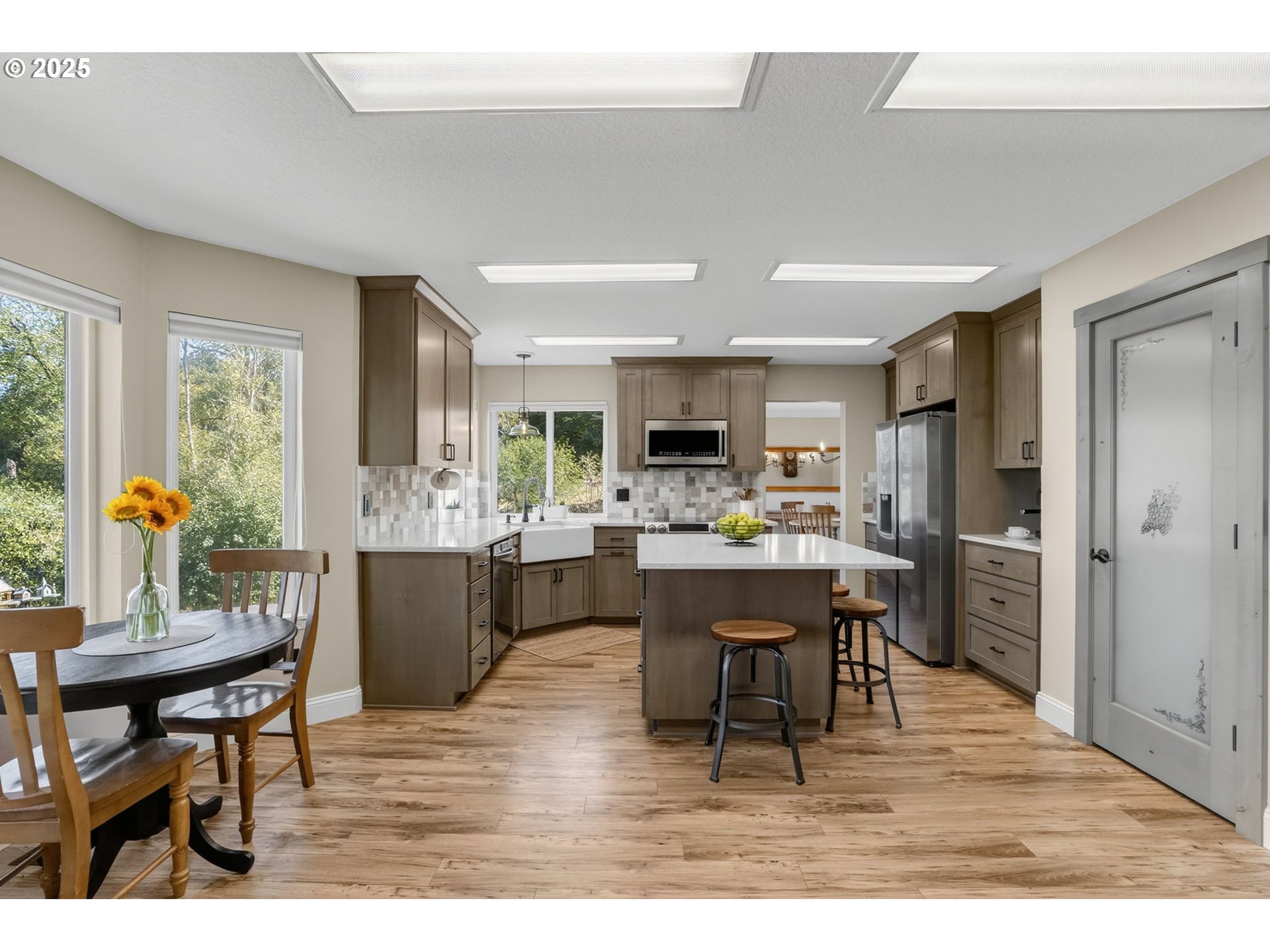 32102 Northwest Eagle Crest Drive Ridgefield, WA 98642 - Photo 12 of 48 a dining hall with stainless steel appliances kitchen island granite countertop a dining table chairs and a refrigerator