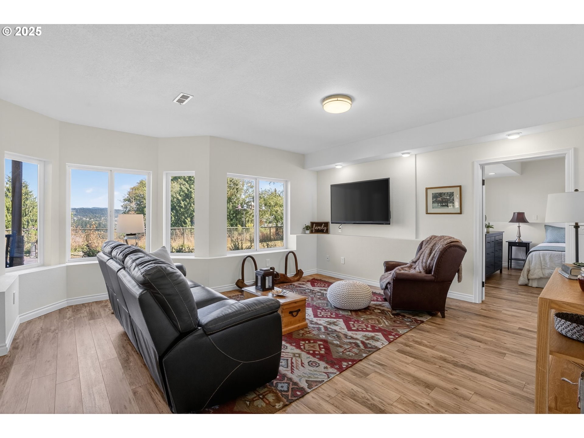 32102 Northwest Eagle Crest Drive Ridgefield, WA 98642 - Photo 32 of 48 a living room with furniture a flat screen tv and a large window