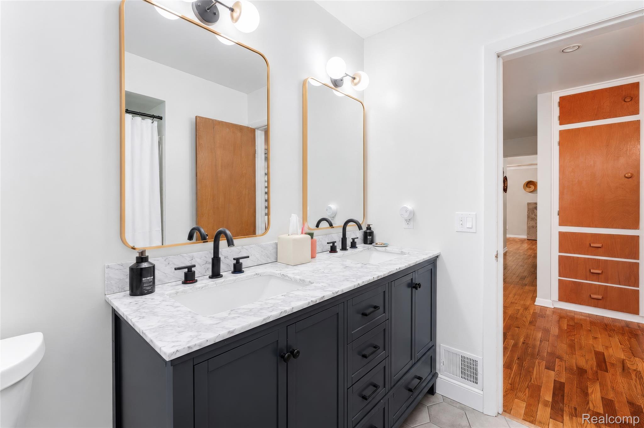 4499 South Linden Road Flint, MI 48507 - Photo 29 of 36 Dual vanity with black cabinetry, white countertops, and matte black fixtures