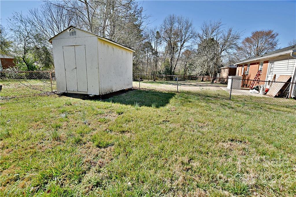 243 Eden Circle Pineville, NC 28134 - Photo 16 of 18 a view of backyard with a garden and trees