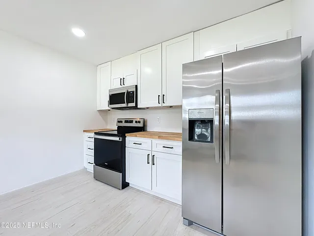 a kitchen with a refrigerator and a stove top oven
