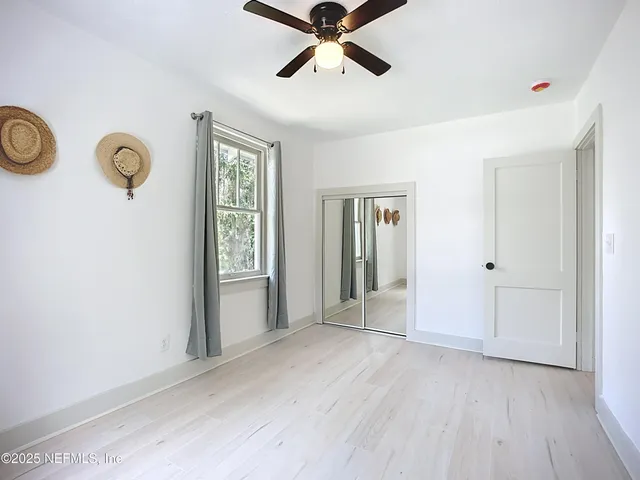 a view of a livingroom with wooden floor and a ceiling fan
