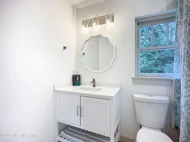 a bathroom with a toilet sink and mirror