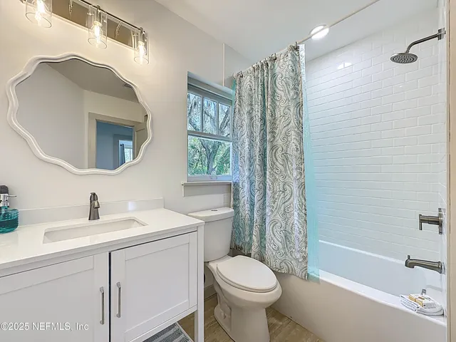 a bathroom with a sink toilet a mirror and shower