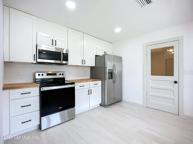 a kitchen with stainless steel appliances a stove a microwave and cabinets