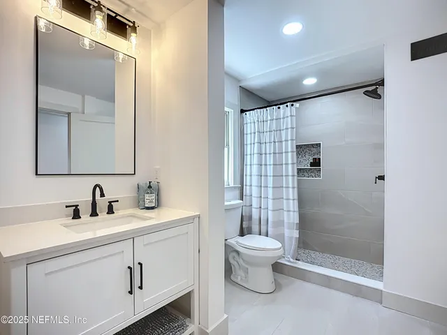 a bathroom with a double vanity sink toilet and shower