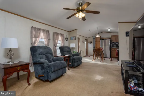 a living room with furniture a ceiling fan and a window